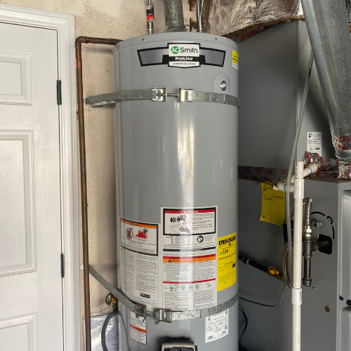 AO Smith water heater installed in a residential setting, showcasing plumbing connections and safety labels relevant to water heating solutions.
